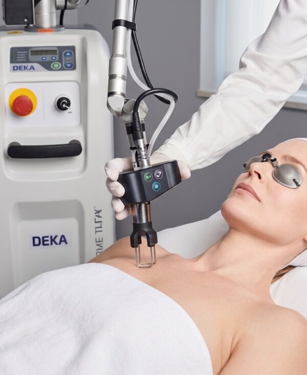 Patient receiving a neck laser treatment, held by gloved clinician using a DEKA device.