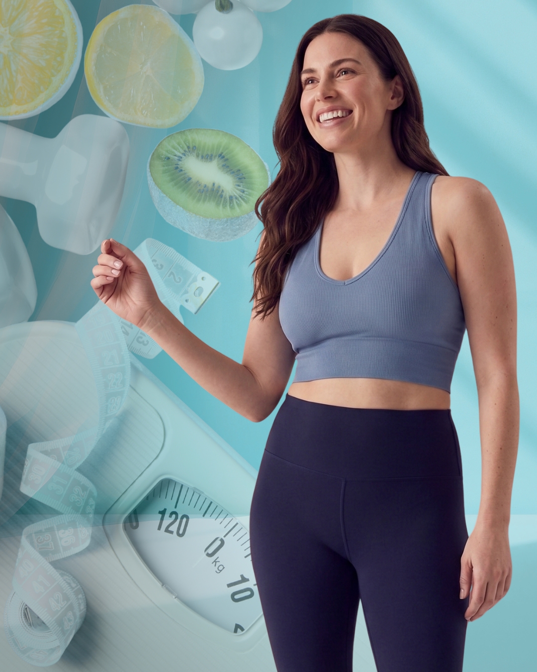 Smiling woman in a blue sports bra and dark leggings with a weighing scale and floating fruit slices in the background.